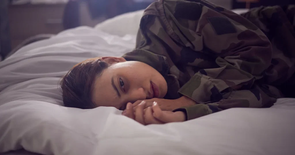 Anxiety and Depression - Young woman in uniform lying in bed displaying Anxiety and Depression